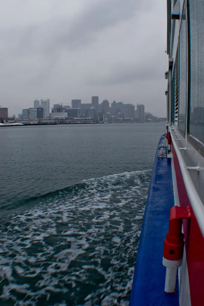 The deck of a boat on the harbor with the skyline behind