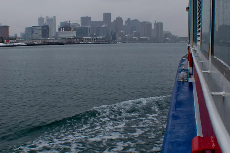 The deck of a boat on the harbor with the skyline behind